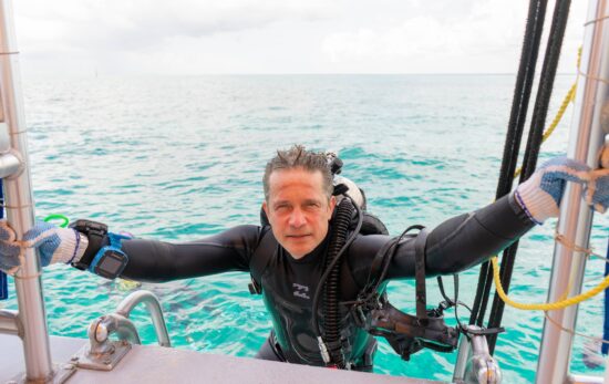 Fabien Cousteau climbs a dive boat ladder