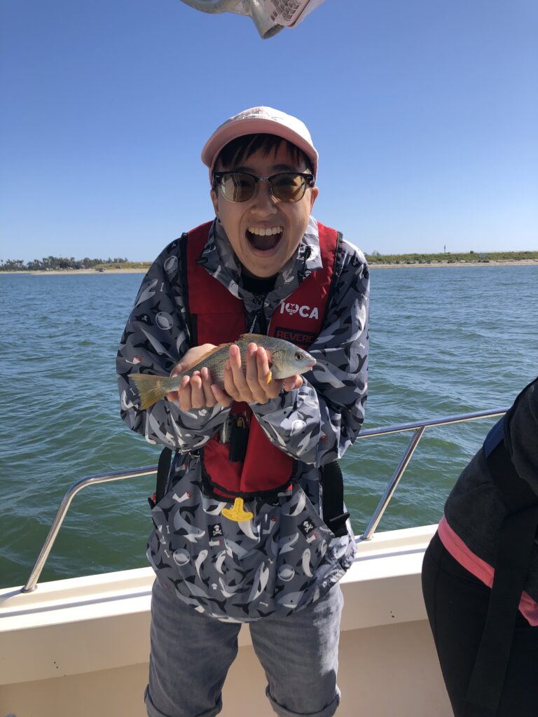 Annabel Gong holds up a fish as part of research.