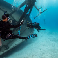 scuba instructor and two divers underwater on a wreck dive