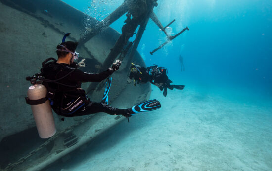 scuba instructor and two divers underwater on a wreck dive