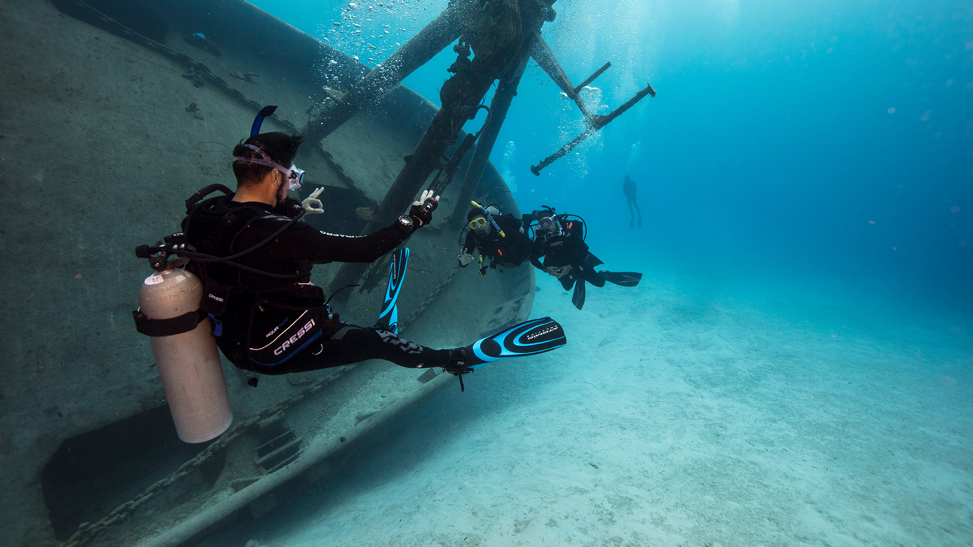 scuba instructor and two divers underwater on a wreck dive