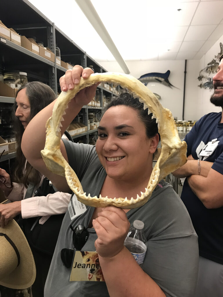 A scientist smiles from within shark jaws.