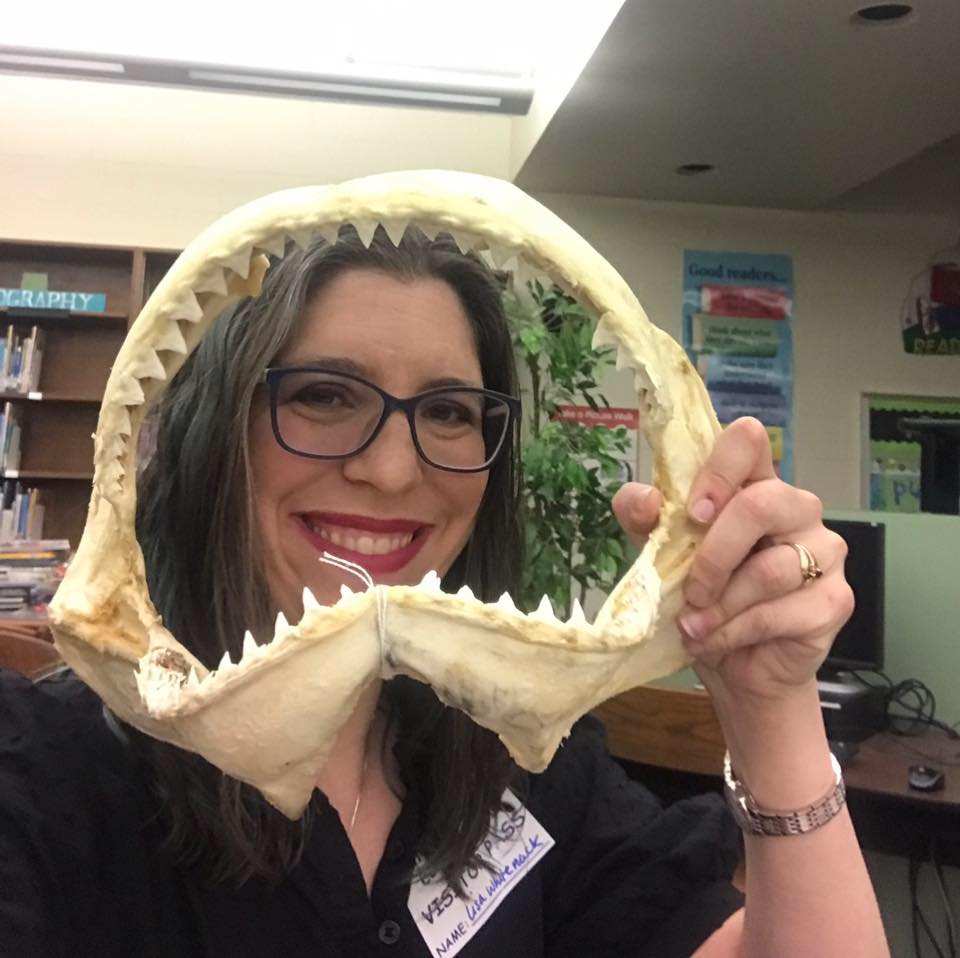 A scientist smiles from within a shark jaw
