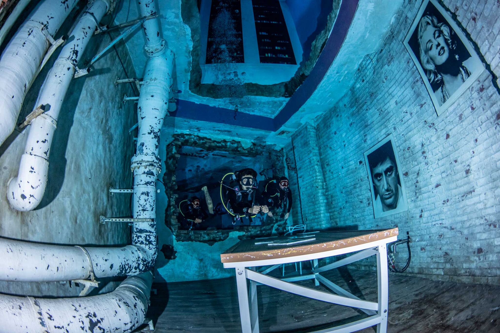 Scuba divers explore the sunken city at Deep Dive Dubai, which holds the Guinness World Record for the deepest pool ever