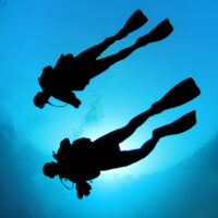 two scuba divers in sillhouette