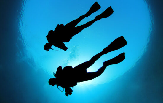 two scuba divers in sillhouette