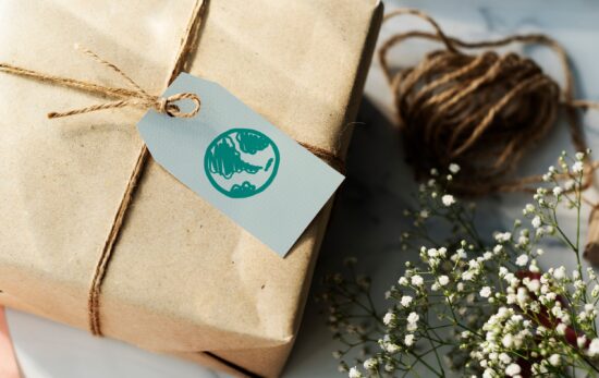A package gift wrapped in brown paper with a gift tag that has a picture of the earth on it