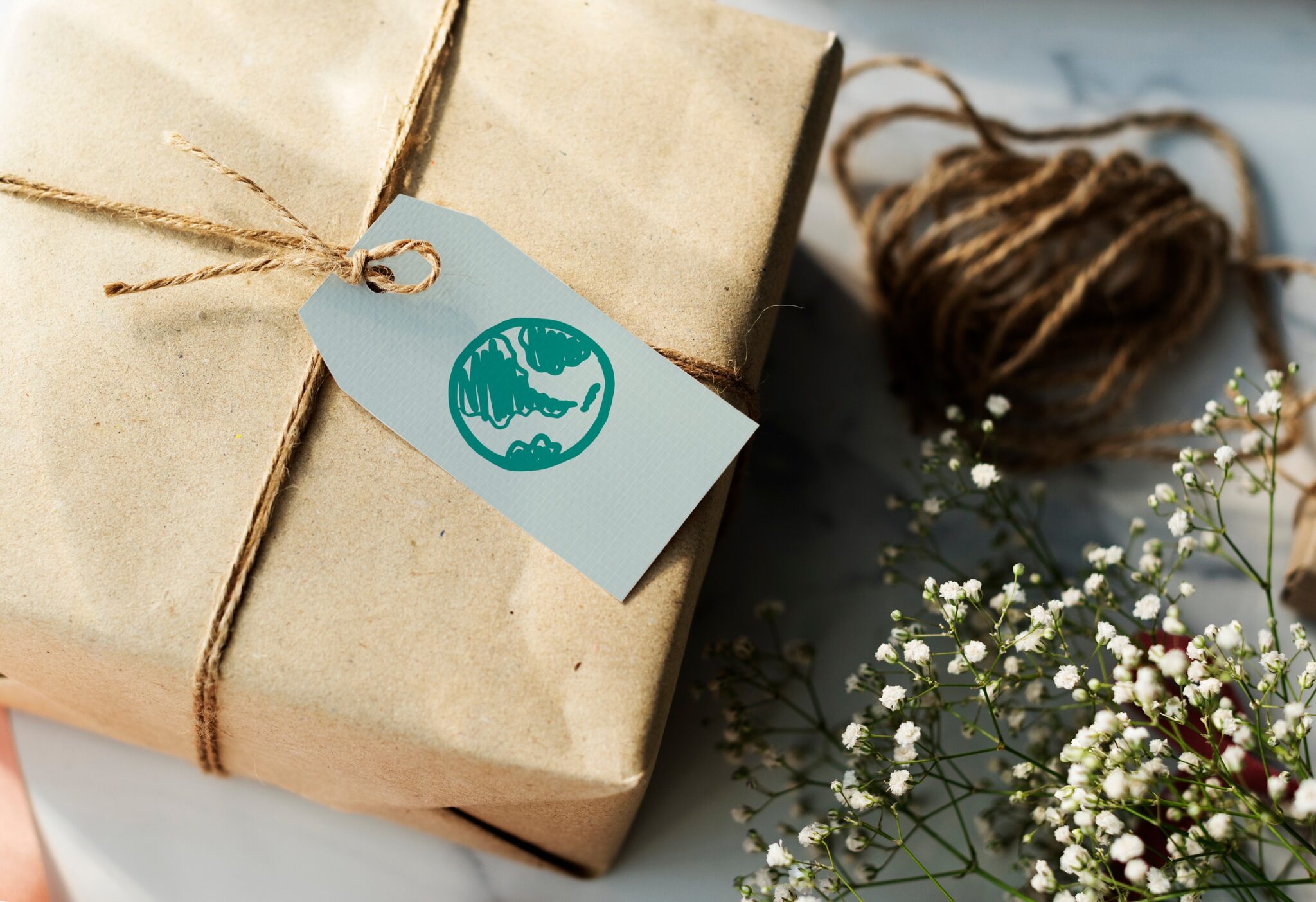 A package gift wrapped in brown paper with a gift tag that has a picture of the earth on it gifts for scuba divers