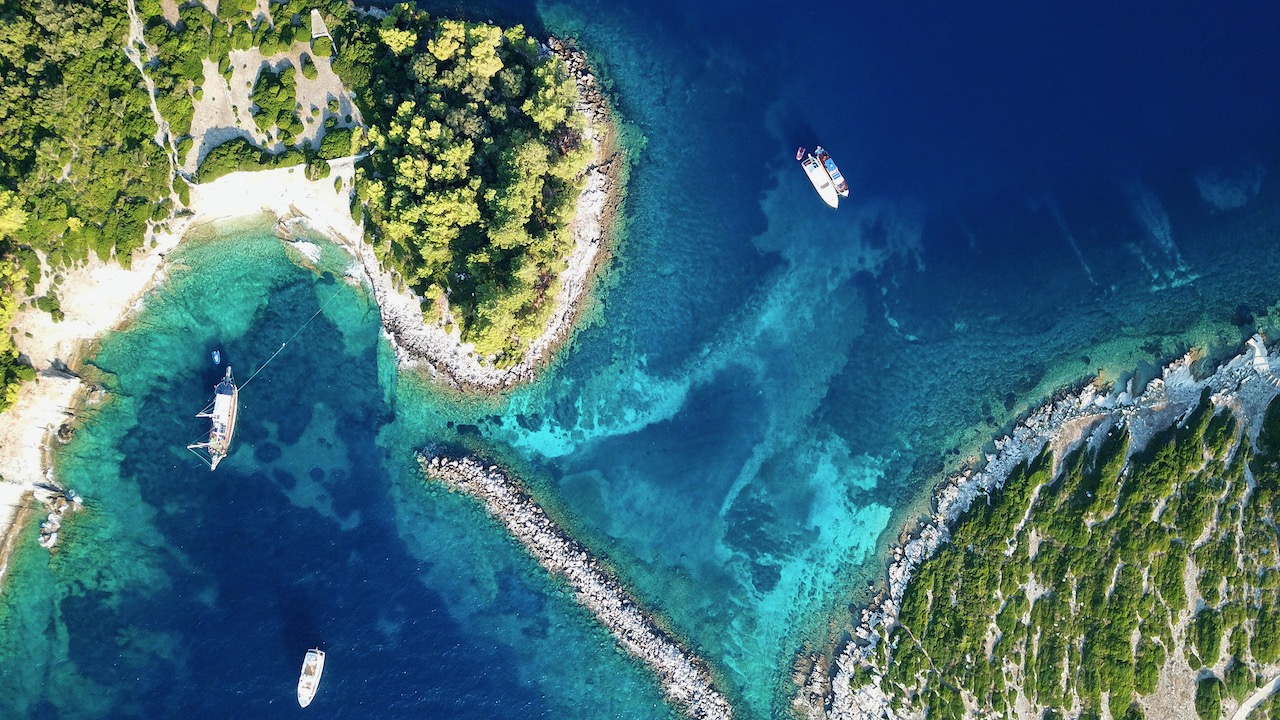An aerial shot of liveaboards anchored in the tropical ocean which helps to answer the question 'what is a liveaboard vessel'