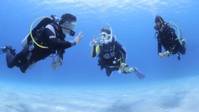 Instructor and student diver communicating with hand signal underwater