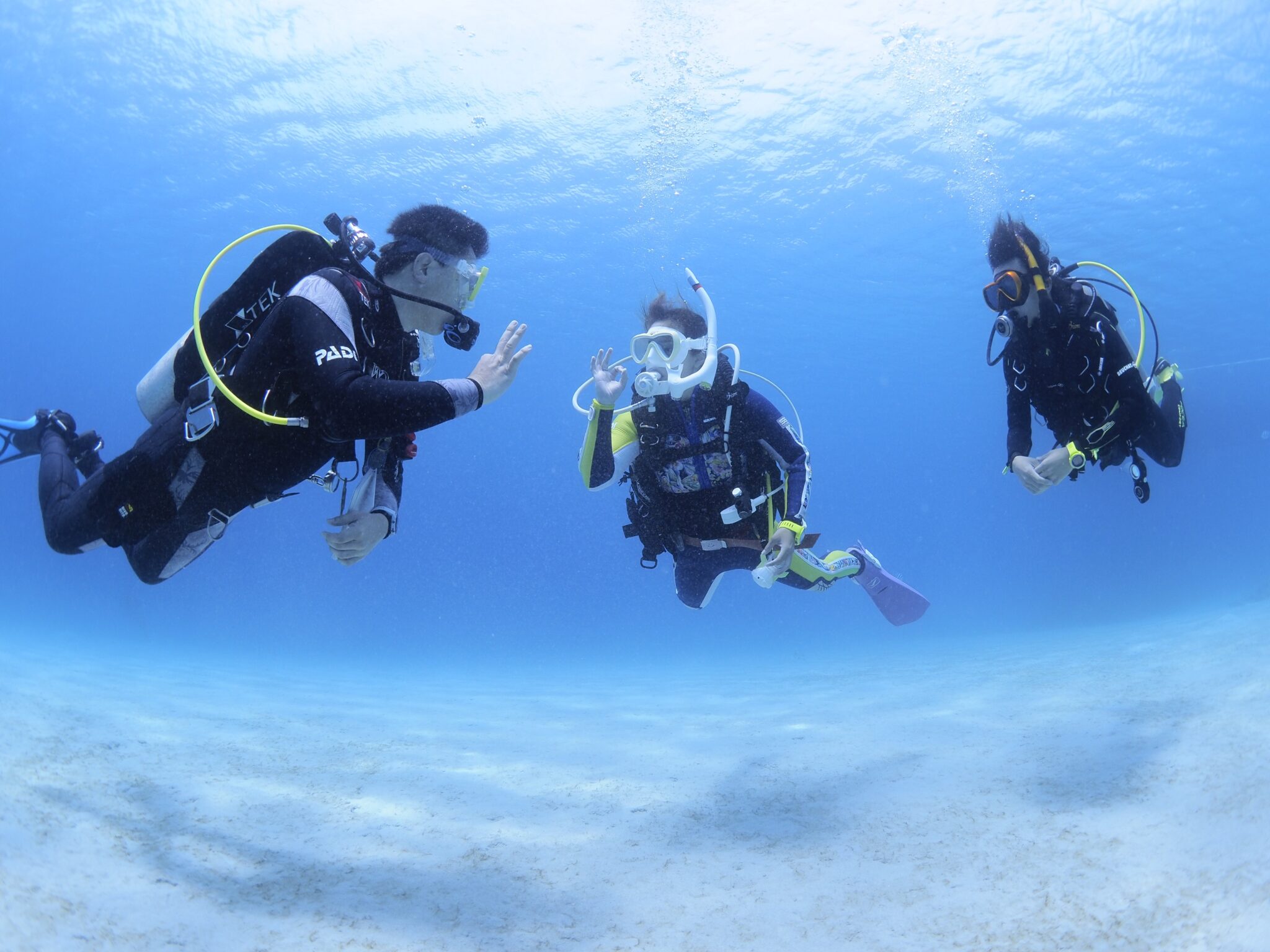 Instructor and student diver communicating with hand signal underwater