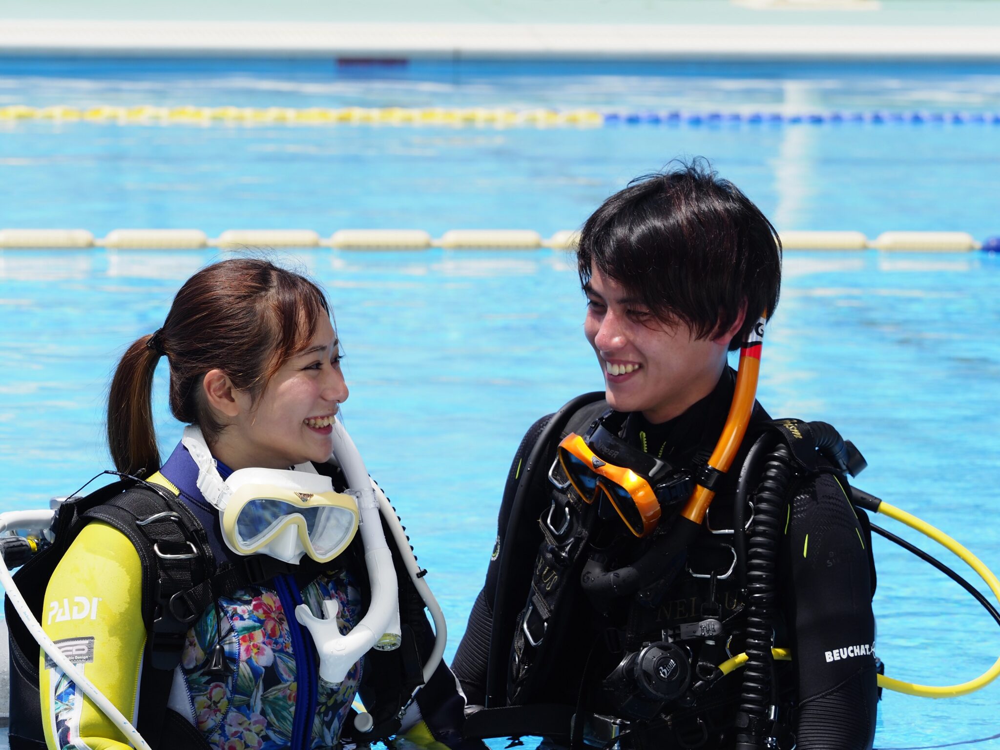 two student divers smiling at each other during confined water dive