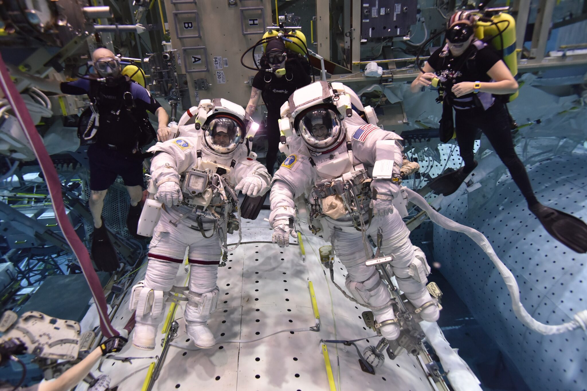 Two astronauts underwater in NASA's Neutral Buoyancy Lab where safety divers have one of the world's best scuba diving jobs