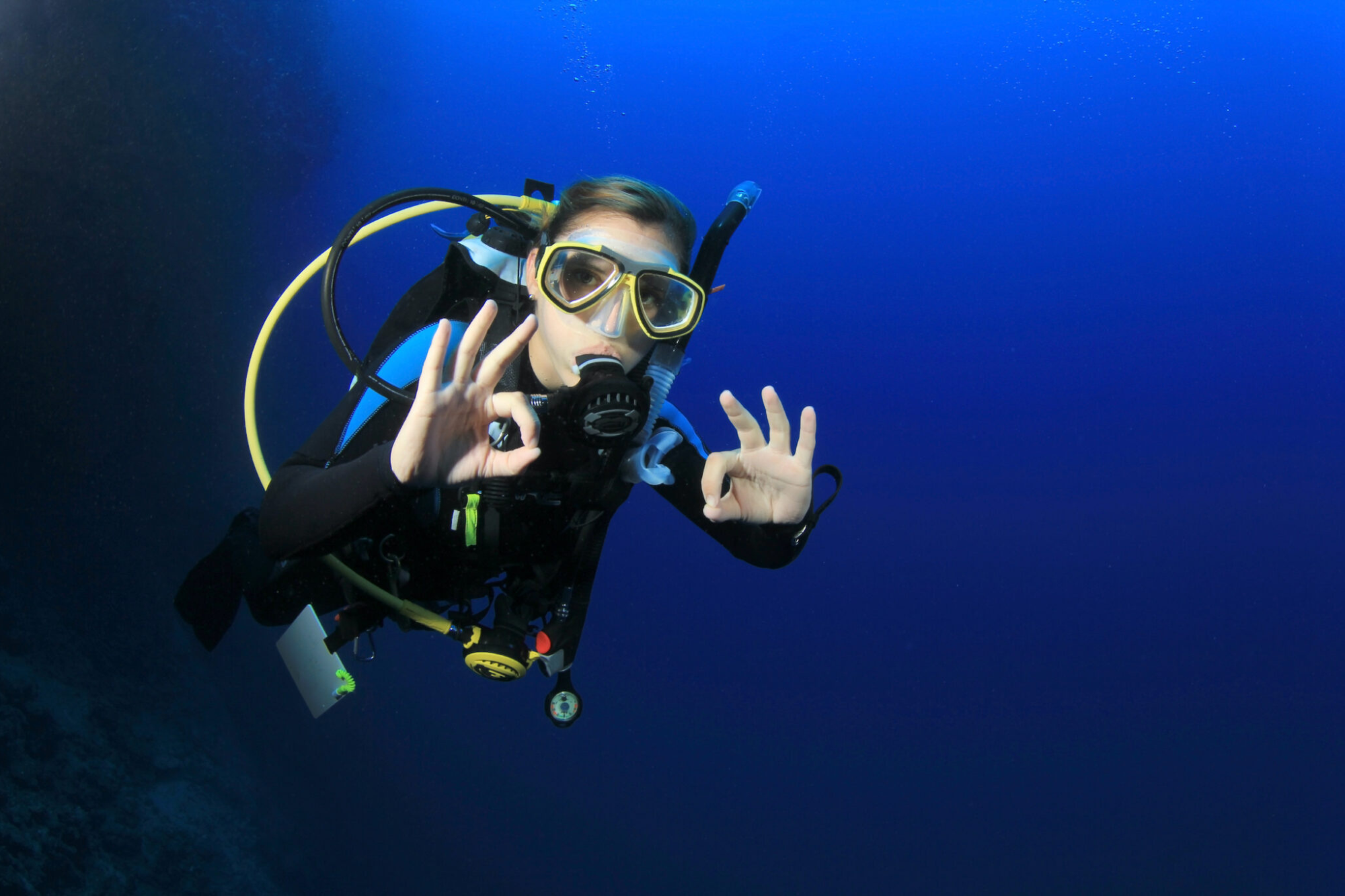 Scuba diver giving the okay hand signal underwater 