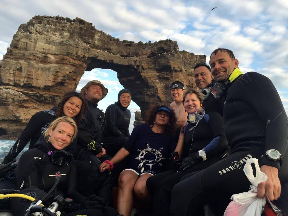 Divers pose for a group photo in front of the iconic Darwin's Arch.