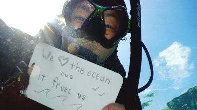 Diver holding a sign that says "We
