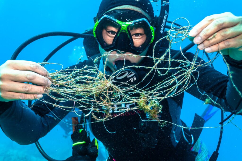 A diver holds up line that was entangled on coral