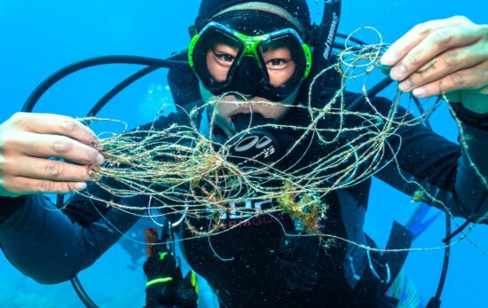 A diver holds up line that was entangled on coral