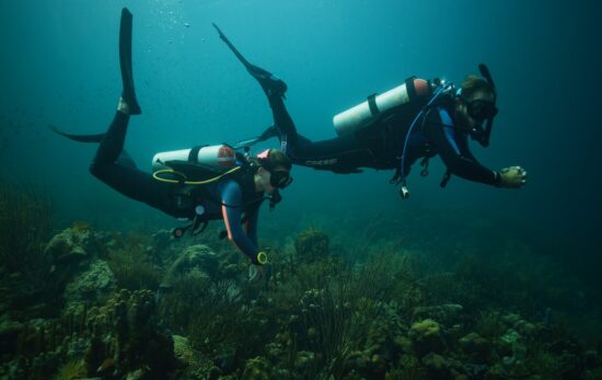 two divers in curacao use excellent buoyancy techniques to improve their air consumption