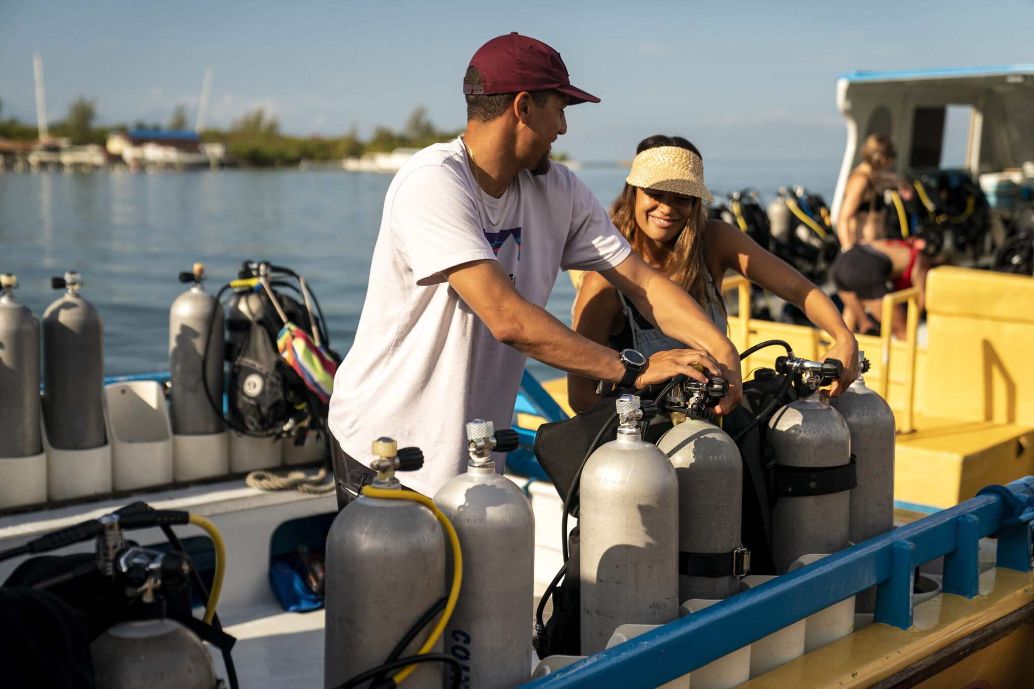 two scuba divers prepare their gear on a dive boat