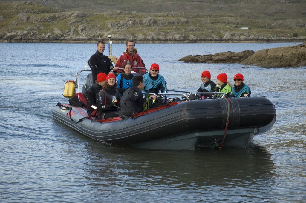 A group of PADI divers on a small dive boat who know how to Live Unfiltered by learning scuba diving in the UK and Ireland