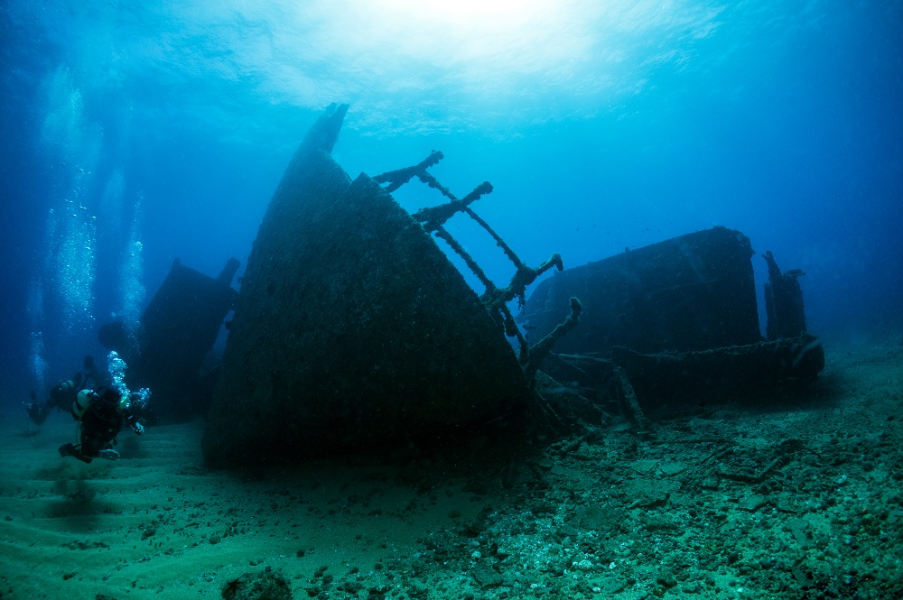 Two scuba divers exploring a shipwreck at 18m/60ft, which is possible as a certified PADI Open Water Diver