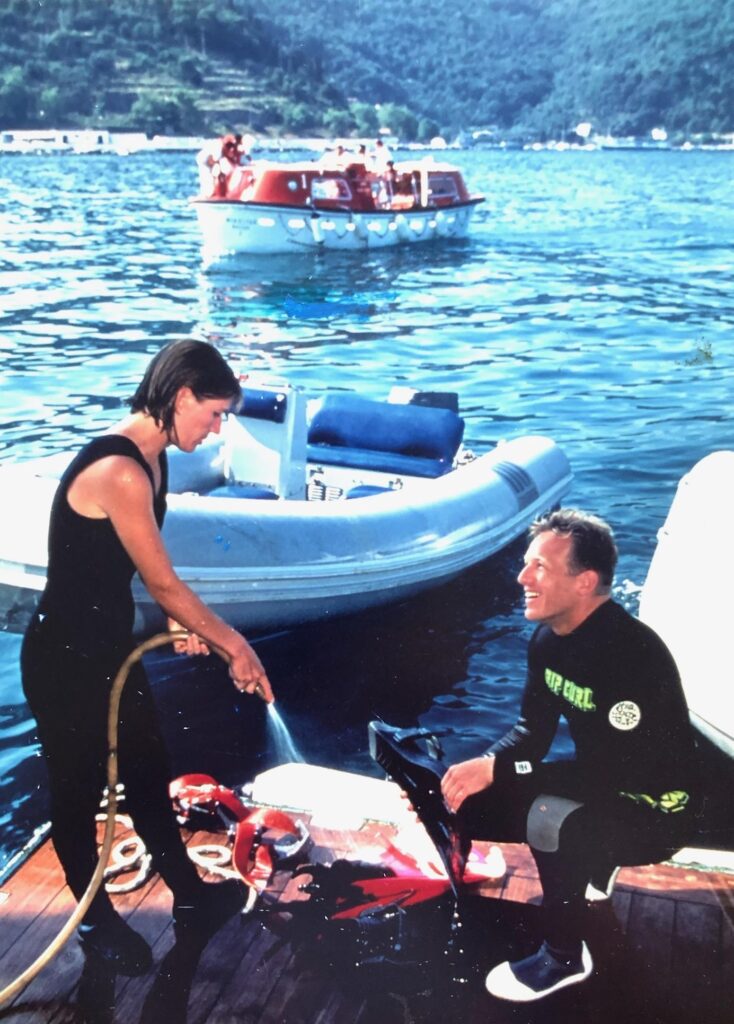 A woman hoses down a BC while a man looks on in a 1995 ad for a diving company.