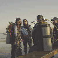 four divers exit the water after a shore dive in the Red Sea, Egypt