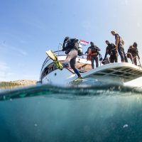 divers entering the water from a boat