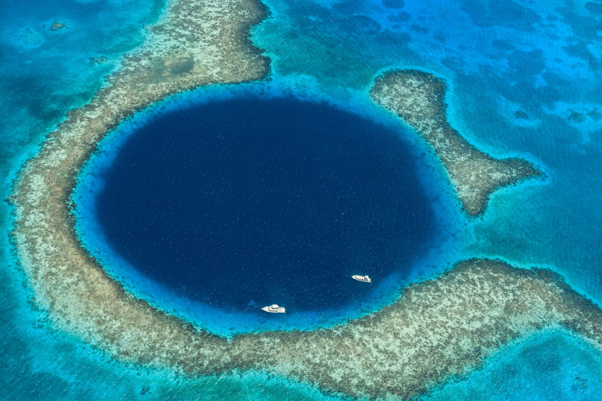 มุมมองทางอากาศของ The Great Blue Hole ในเบลีซ ซึ่งเป็นหนึ่งในจุดหมายปลายทางการดำน้ำฟรีที่มีชื่อเสียงที่สุดในโลก