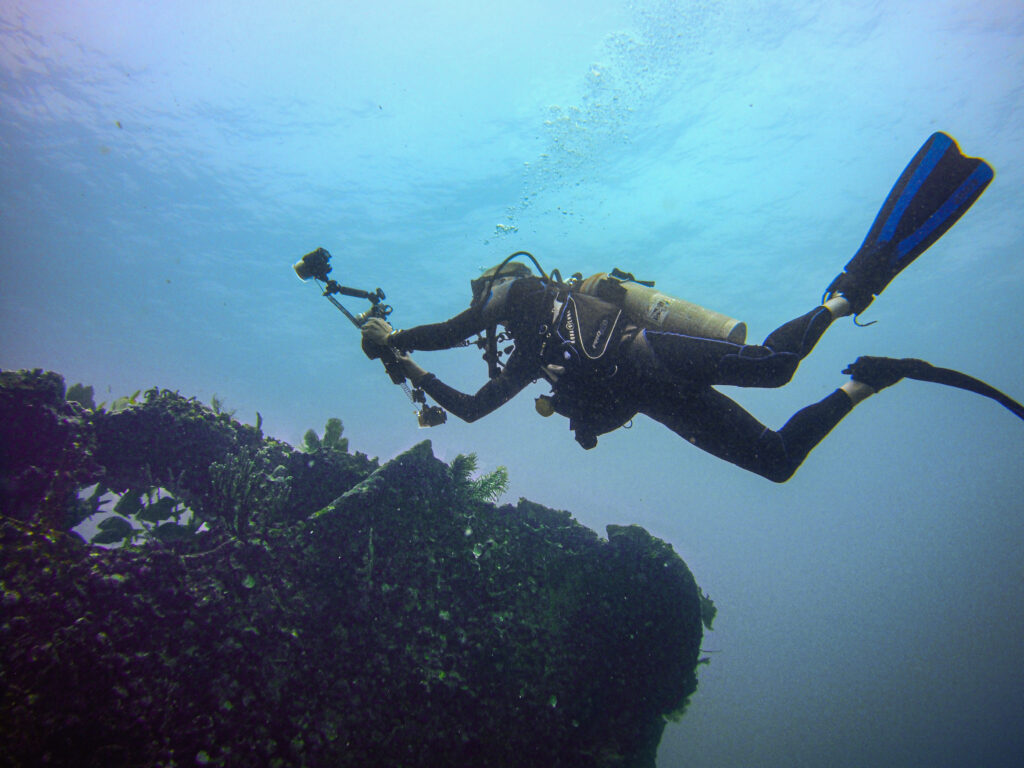 Scuba diver taking a picture of The Wreck of the Benwood, located in the Florida Keys.