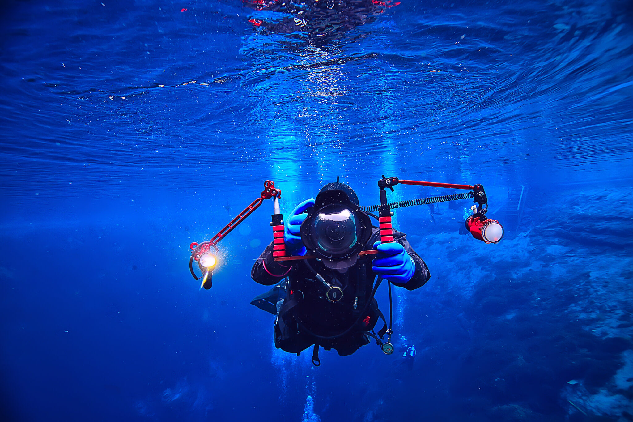 An underwater photographer with a professional camera and strobe set-up, one of many different types of scuba diving careers