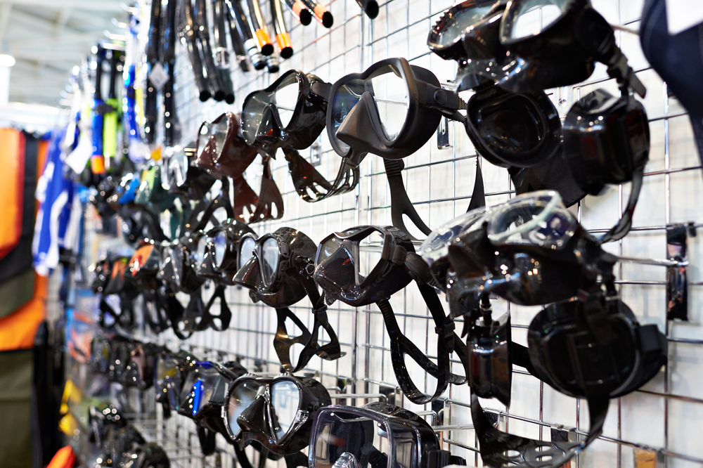 A display of scuba diving masks on the wall in a PADI Dive Shop, a business that offers great scuba diving job opportunities