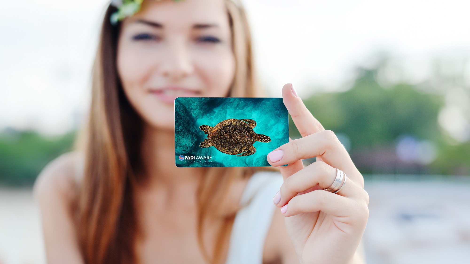 a woman holding a sea turtle padi certification card