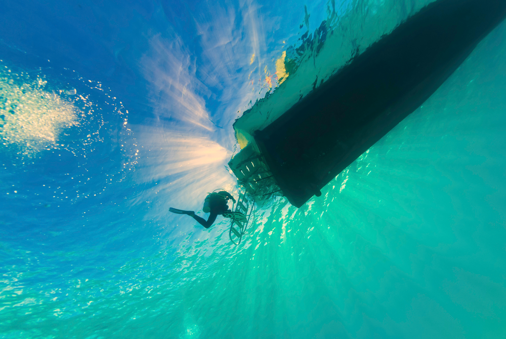 a diver exits the water using a boat ladder