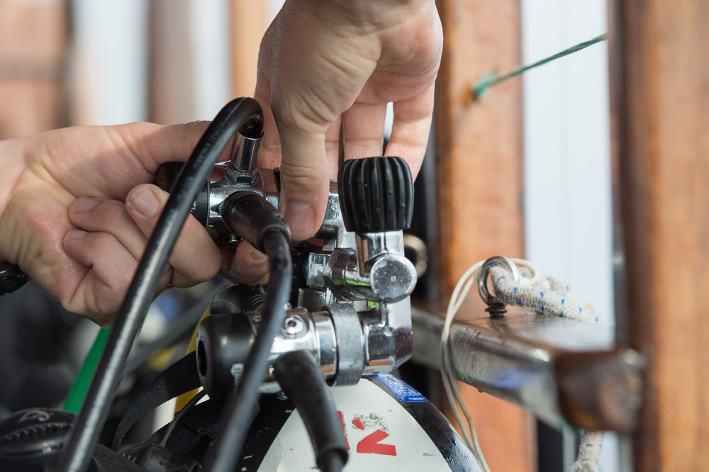 A diver kitting up who has followed the top scuba liveaboard tips by making sure to pack plenty of spare diving equipment
