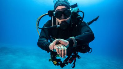 A scuba diver checking a dive computer
