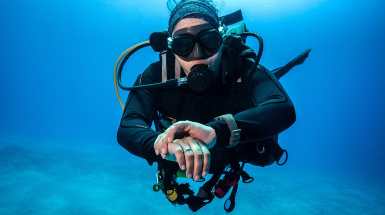 A scuba diver checking a dive computer