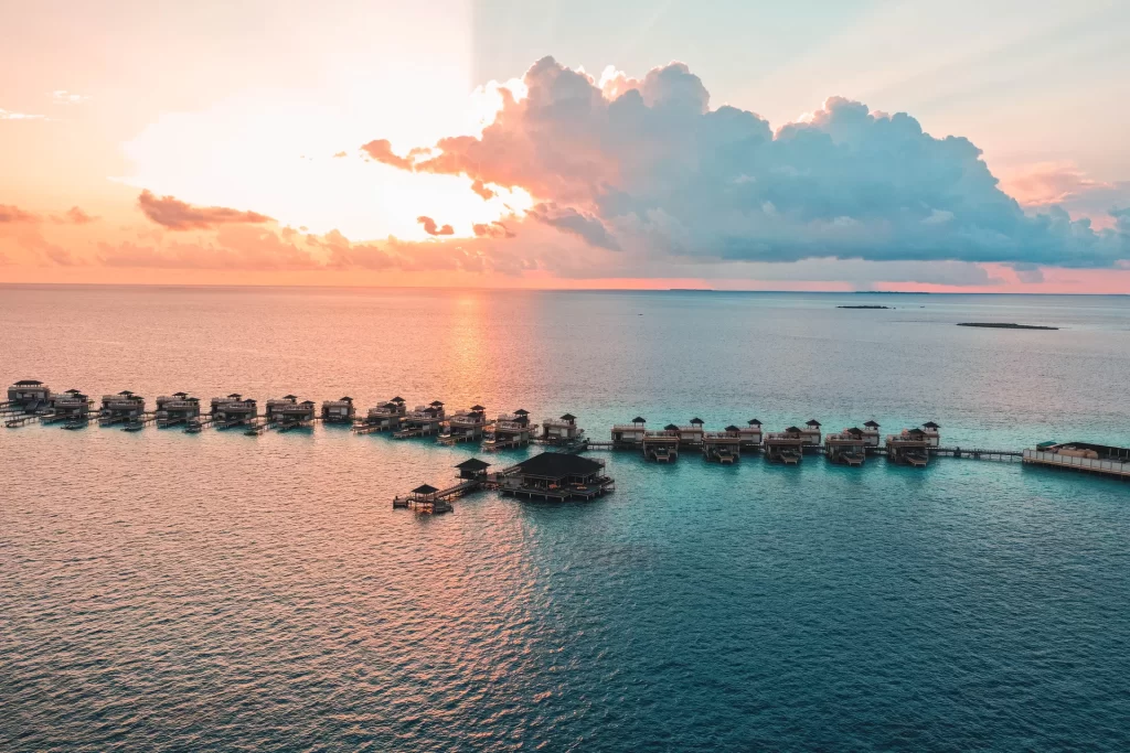 sunset view of the overwater bungalows at Angsana Velavaru resort in the Maldives