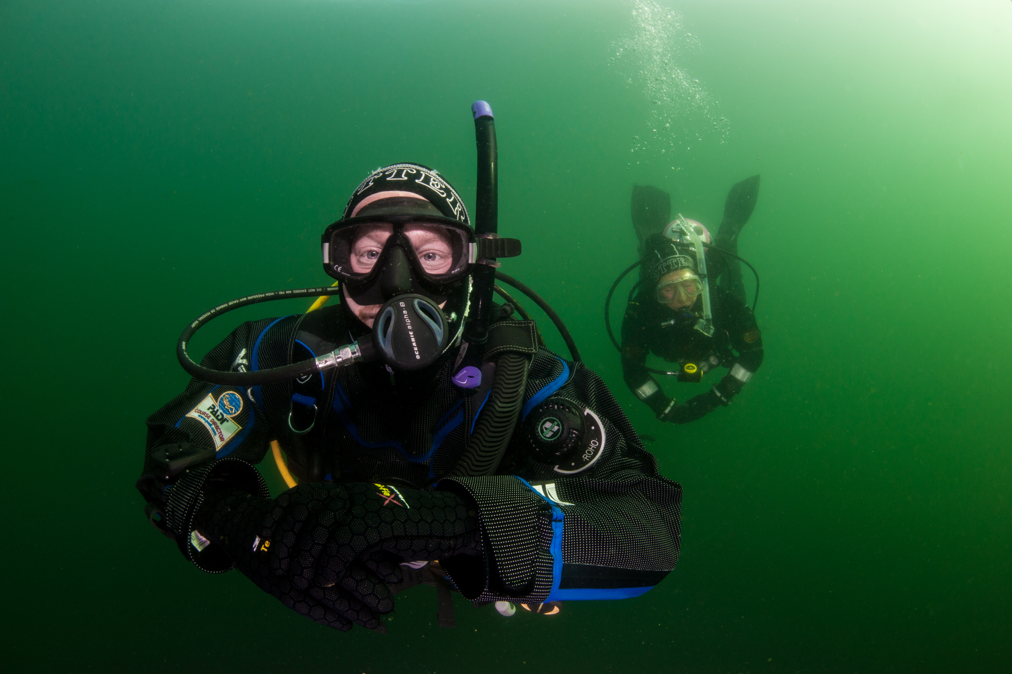 Two PADI divers in a drysuit exploring a German lake