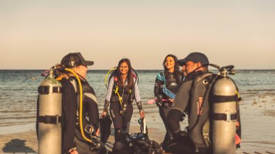 Divers ready to take ocean conservation action this AWARE Week. Divers are gearing up with a beautiful ocean background.