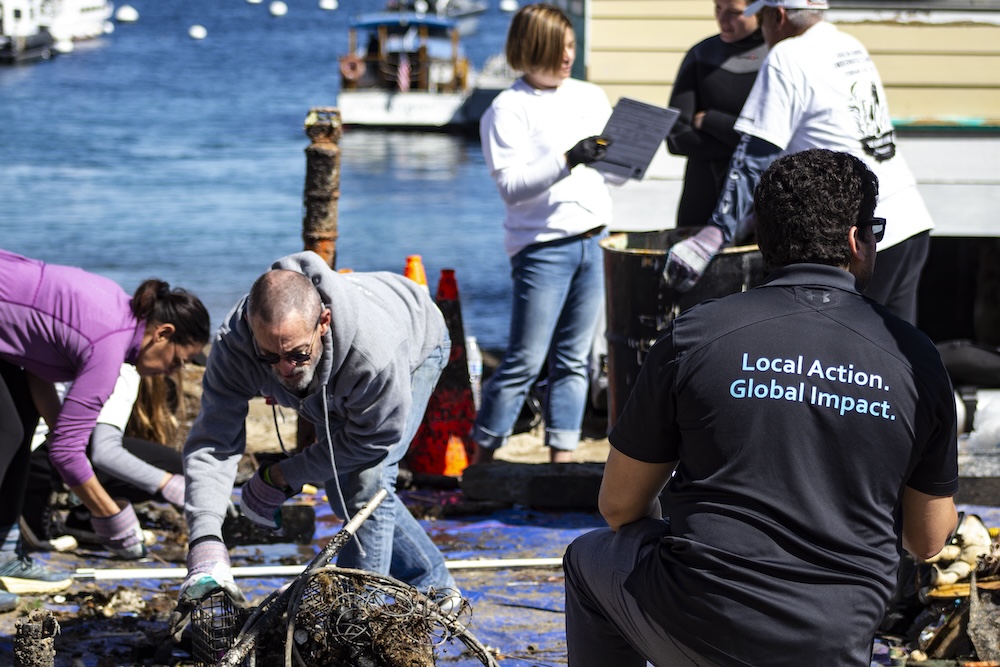 자원봉사자들은 해변에서 다이버들이 발견한 해양 쓰레기를 기록하는 작업을 합니다.