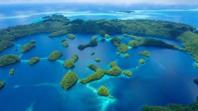 An aerial view of lush green islands tucked among blue bays