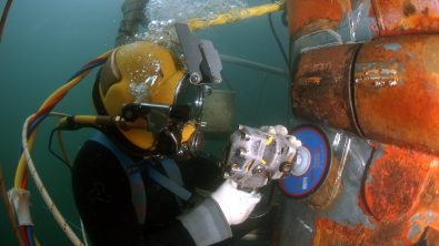 A commercial diver doing underwater grinding to repair the OSS Ogden