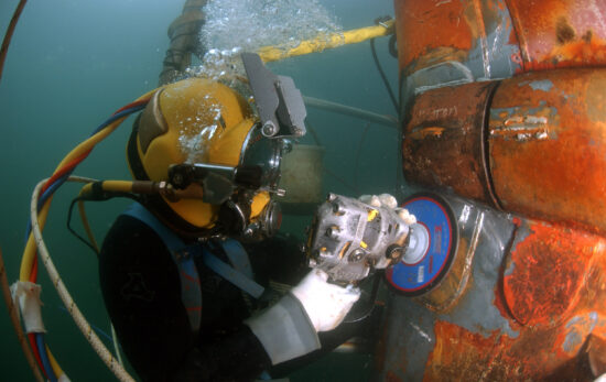 A commercial diver doing underwater grinding to repair the OSS Ogden