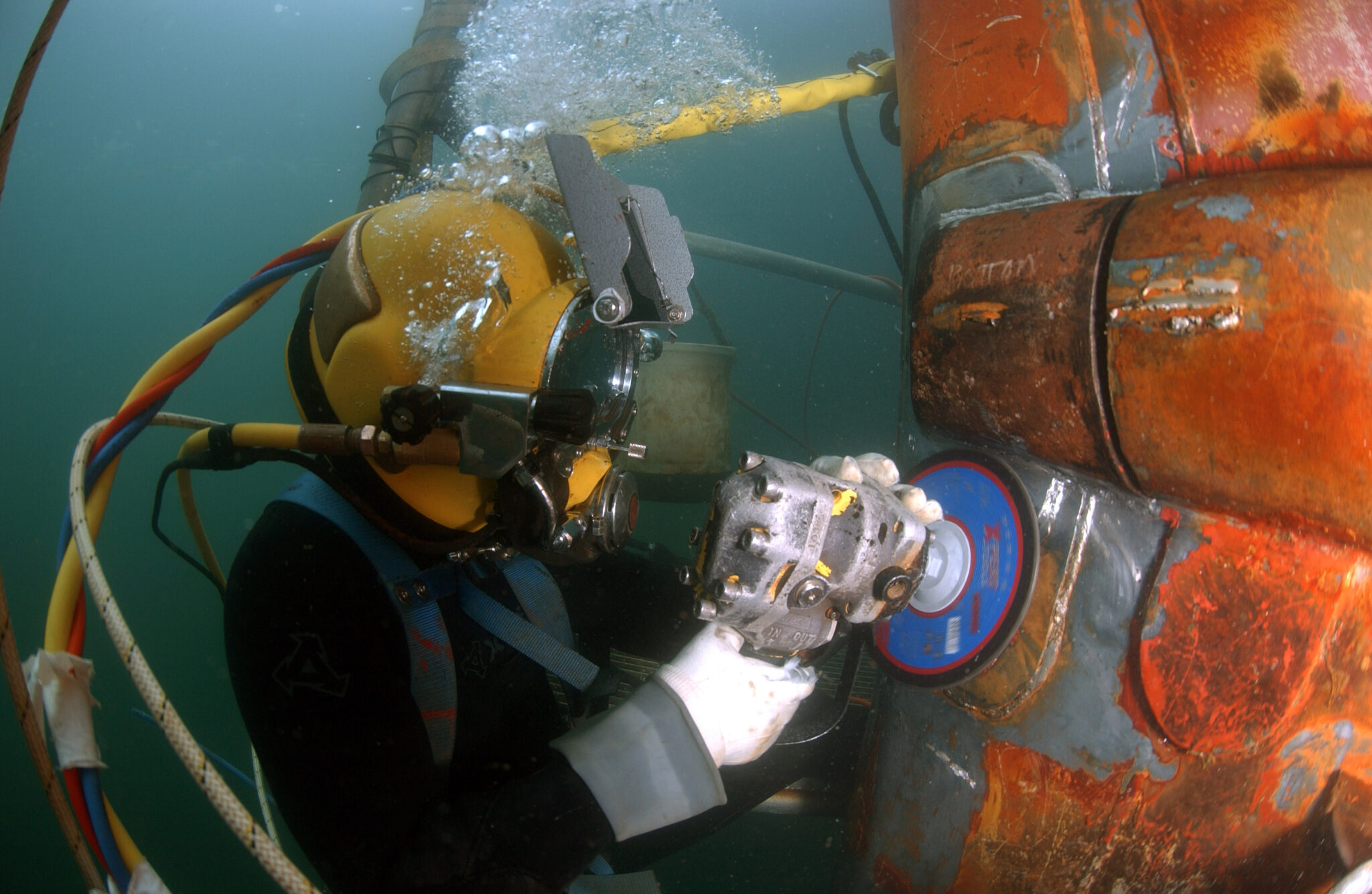 A commercial diver doing underwater grinding to repair the OSS Ogden