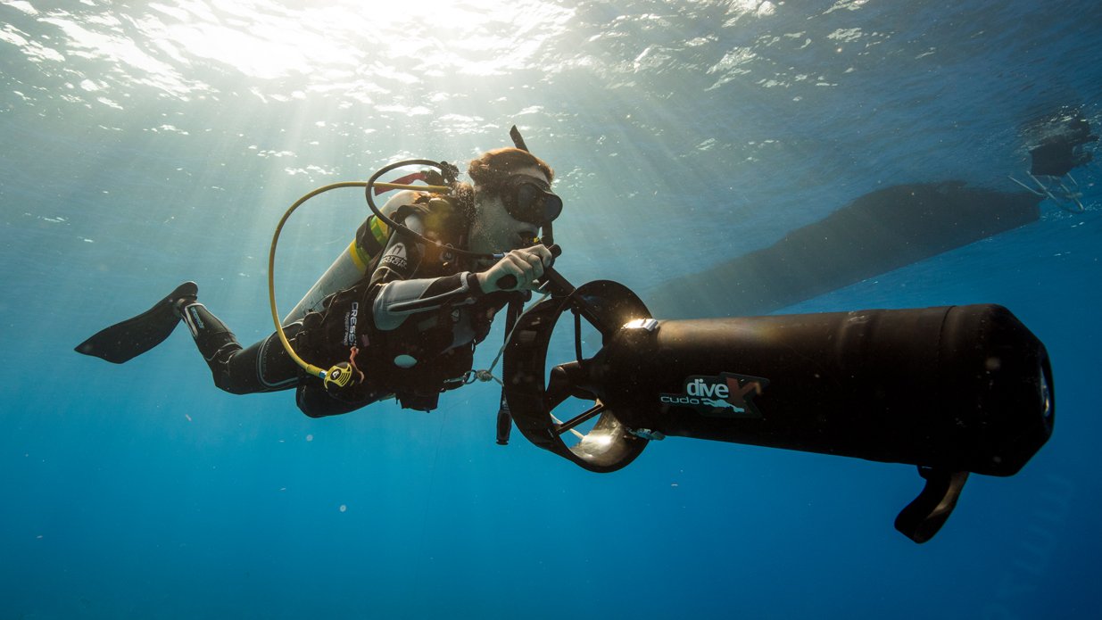 A scuba diver playing with an underwater scooter, one of many underwater sports and diving games that certified divers enjoy