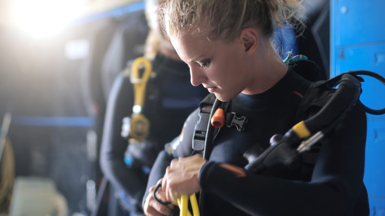 diver fitting gear on dive boat