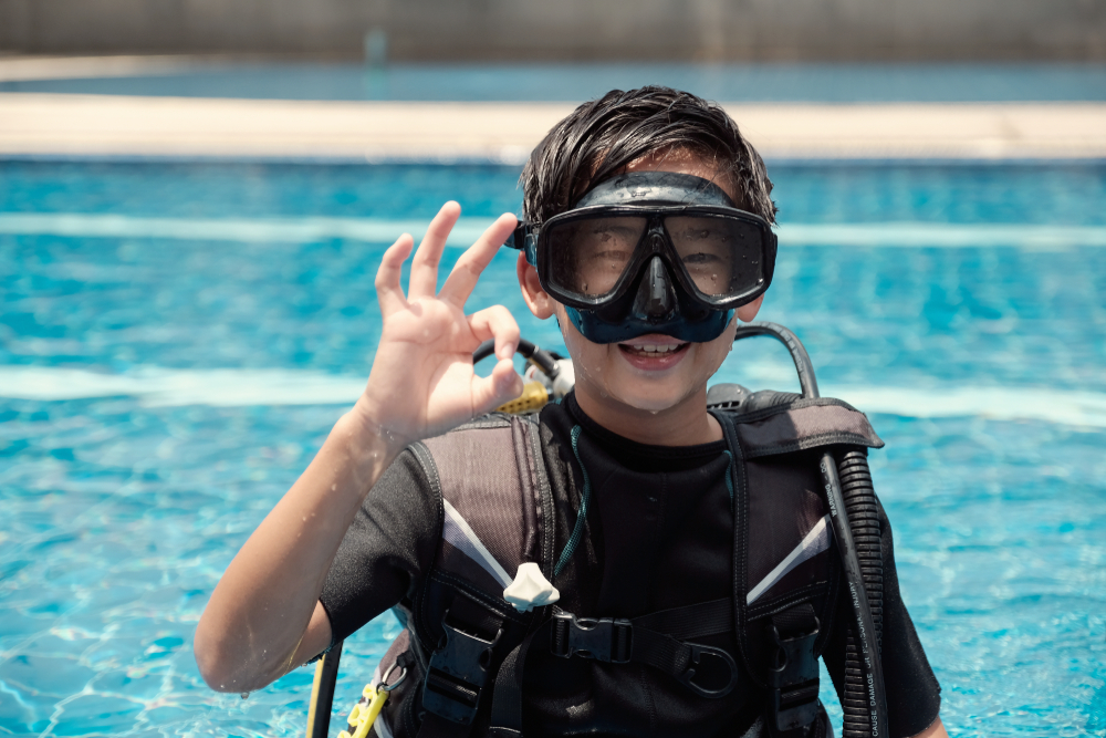 a child scuba diver gives the 'ok' sign