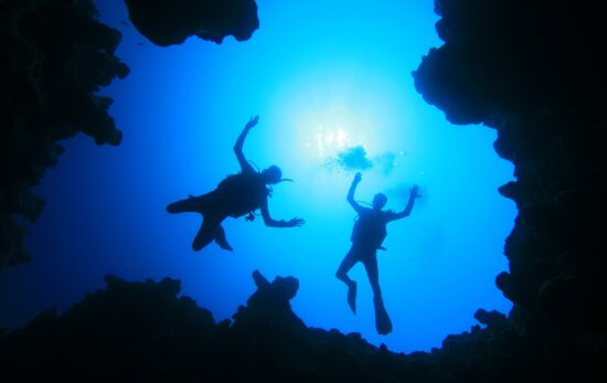 two scuba divers descend from above